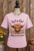 Just a Girl Who Loves Cows Highland Cow Graphic T-Shirt in dusty mauve-pink #E4C6D4 with rustic barn wood background